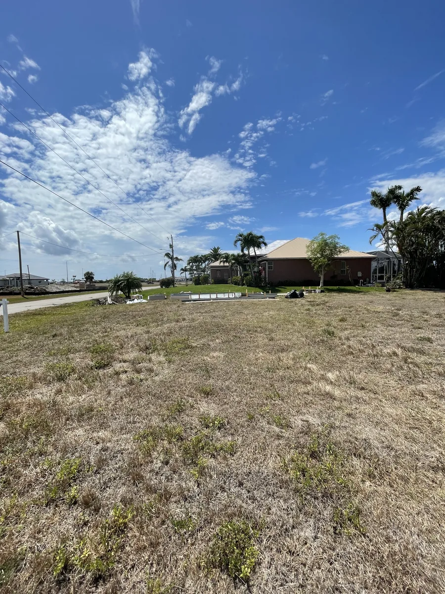 Cape Coral lot before the house was built, with grass and neighboring homes.